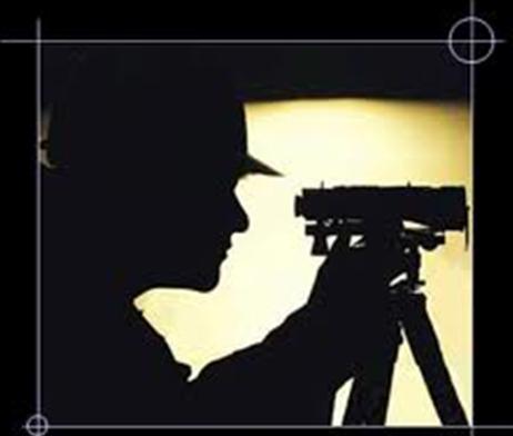 Surveyor using a surveying instrument on a tripod